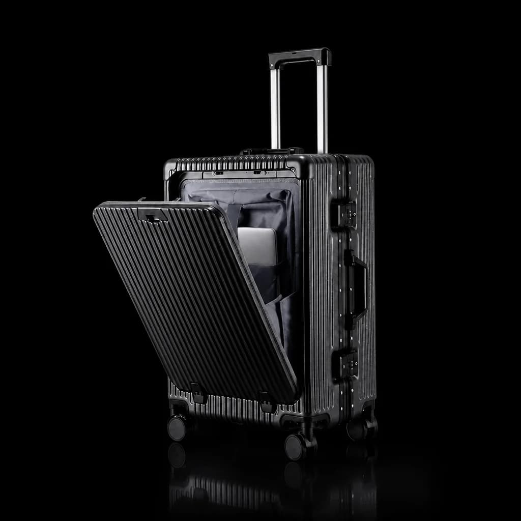 The carry-on emerging from darkness under a single light
